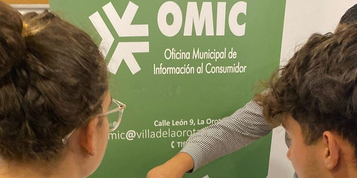 usuarios en oficina turismo cogiendo toalla y folleto 1 vert