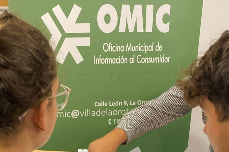usuarios en oficina turismo cogiendo toalla y folleto 1 vert