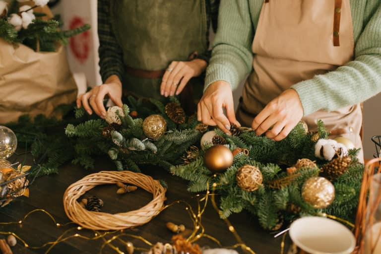 Two,Millennial,Women,Making,Christmas,Wreath,Using,Fresh,Pine,Branches
